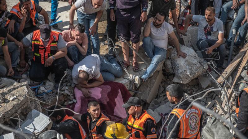 الدفاع المدني الفلسطيني يبحث عن أشخاص تحت أنقاض مبنى مدمر بعد غارة جوية إسرائيلية على غزة