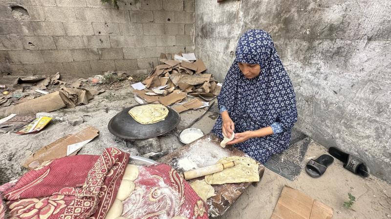 تقوم أم خالد بإعداد الخبز بنفسها لإطعام عدد من النازحين - الأناضول