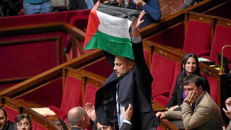 النائب عن حزب فرنسا الأبية سيباستيان ديلوغو يرفع علم فلسطيني خلال جلسة للجمعية الوطنية